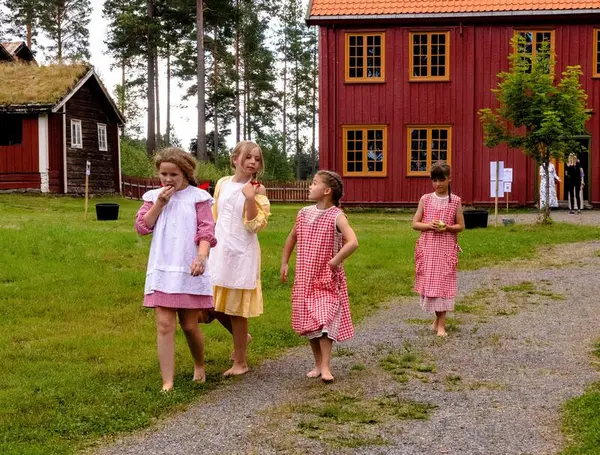 Barneflokk, i kostymer fra begynnelsen av 1900-tallet, på Åmottunet