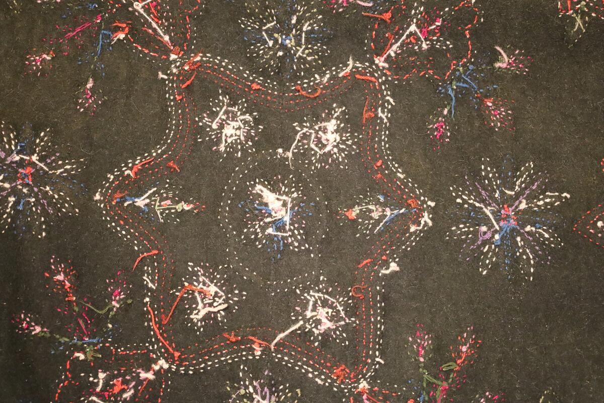 Åkle brodert med blomster, blader, bladranker og grener i ulike farger og størrelser.