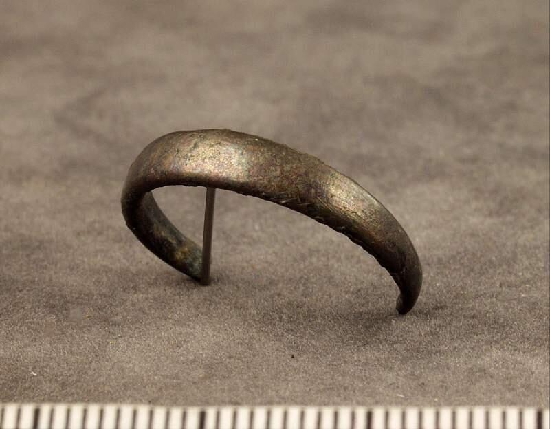 Av slät oornerad något välvd ten, ca en tredjedel av ringen saknas, funnen vid undersökning av fröjel kyrkas grund, genomförd 1935.
av Silver, omkretsen svagt välvd, slät, 1/3 av omkretsen saknas. Diam. 2,1 cm.