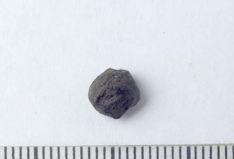 Liten runt och bränt fragment av kärna ?,  från grav 8, en brandgrav (under flat mark ?) i en kistliknande konstruktion påträffad strax intill grav 6, undersökningen vid smiss i när utfördes 1946 av greta arwidsson. Undersökningen omfattade 12 gravar, ytterligare en grav undersöktes tidigare av mårten stenberger 1945. Några av de tolv gravarna hade redan skadats av markarbeten då undersökningen tog vid, en av gravarna, grav 1, var helt fyndtom och flera andra innehöll endast brända ben (och kol), rapport över undersökningen finns i gotlands fornsals arkiv med koncnr 30/47, kopia i ark mag
från smiss i när, grav 8.