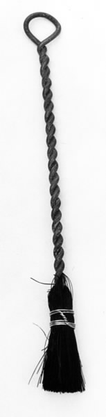 a) Symaskin av märket Husqvarna, modell V.S.4. Handdriven. Svartmålad på träplatta. Nersänkt låda med tillbehör. b) Huv av ekfaner. Handtag på toppen. c) Skyttel av stål. Rund, spetsig i ena änden, rak i den andra. Innehåller en spole med vit tråd. d) Fem spolar av stål. Rund stav med plattor i ändarna. Olika trådrester. e) Ledpressarfot (monterad på maskinen). f) Fållvikare 2 mm. g) Fållvikare 6 mm. h) Gansapparat. i) Rynkfot .j) Linjal. Längd 5,3 cm. k) Fem symaskinsnålar i olika grovlekar. Cellofanförpackning. l) Skruvnyckel. Typ lång platt nål, bakre delen försedd med runt hål. m) Skruvmejsel av stål. Fäste av svart bakelit. n) Borste av dubbelvriden ståltråd med en borste i ena änden. o) Skruvmejsel av stål. Fäste av svart bakelit. p) Provlapp av bomullsflanell. För kontroll av stygnställning. q) Provlapp av bomyllskypert. Till kontroll av stygnställning. r) Bruksanvisning. Tryckt broschyr på 30 sidor.