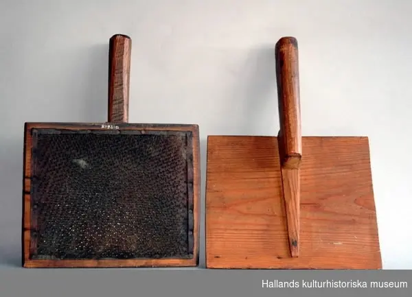 Ett par kardor, för kardstol, försedda med stålpiggar på läderbotten. Längd med handtag: 32,9 cm, Bredd: 23,5 cm.