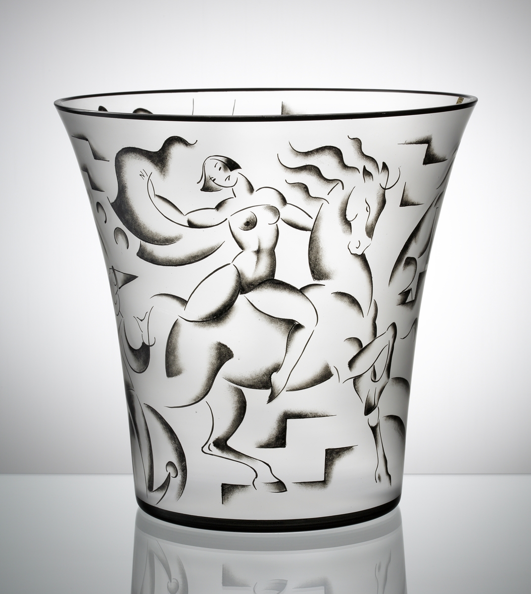 Vas "Cirkus", formgiven av Vicke Lindstrand till Stockholmsutställningen 1930. Ofärgad vas med svart mynningskant, och svartmålad dekor föreställande scener ur en cirkus: En jonglerande clown, en oklädd kvinna på en häst och en elefant.