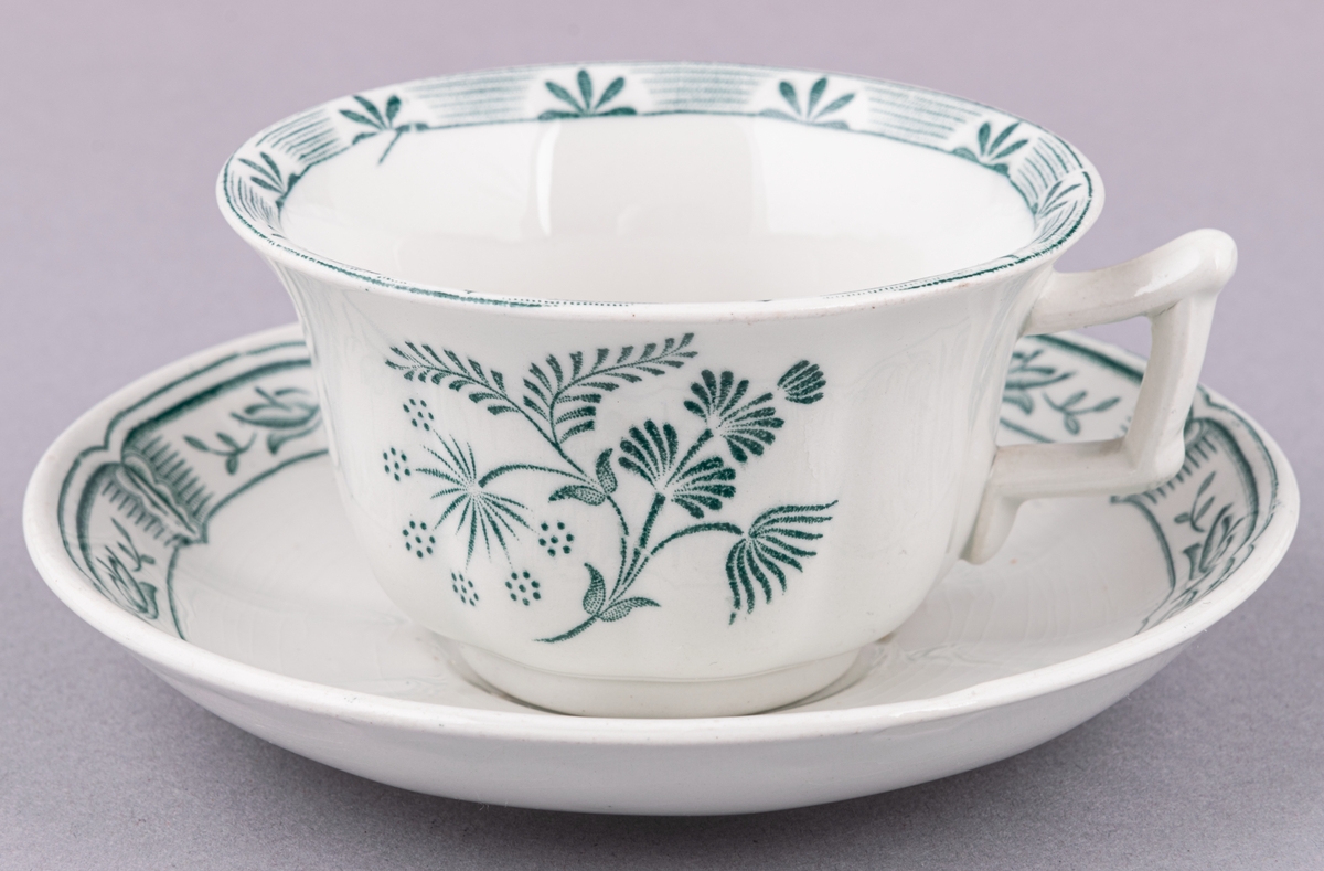 Kaffekopp med fat, i flintgods. Modell O, dekor Kerstin. Vit glasyr med grönt blommönster. Skapad av Arthur Percy för Gefle Porslinsfabrik 1933.