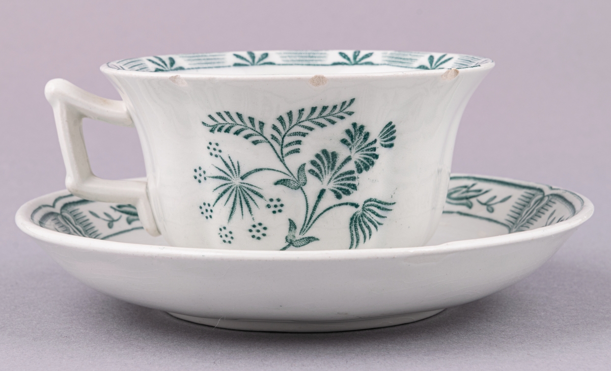 Kaffekopp med fat, i flintgods. Modell O, dekor Kerstin. Vit glasyr med grönt blommönster. Skapad av Arthur Percy för Gefle Porslinsfabrik 1933.