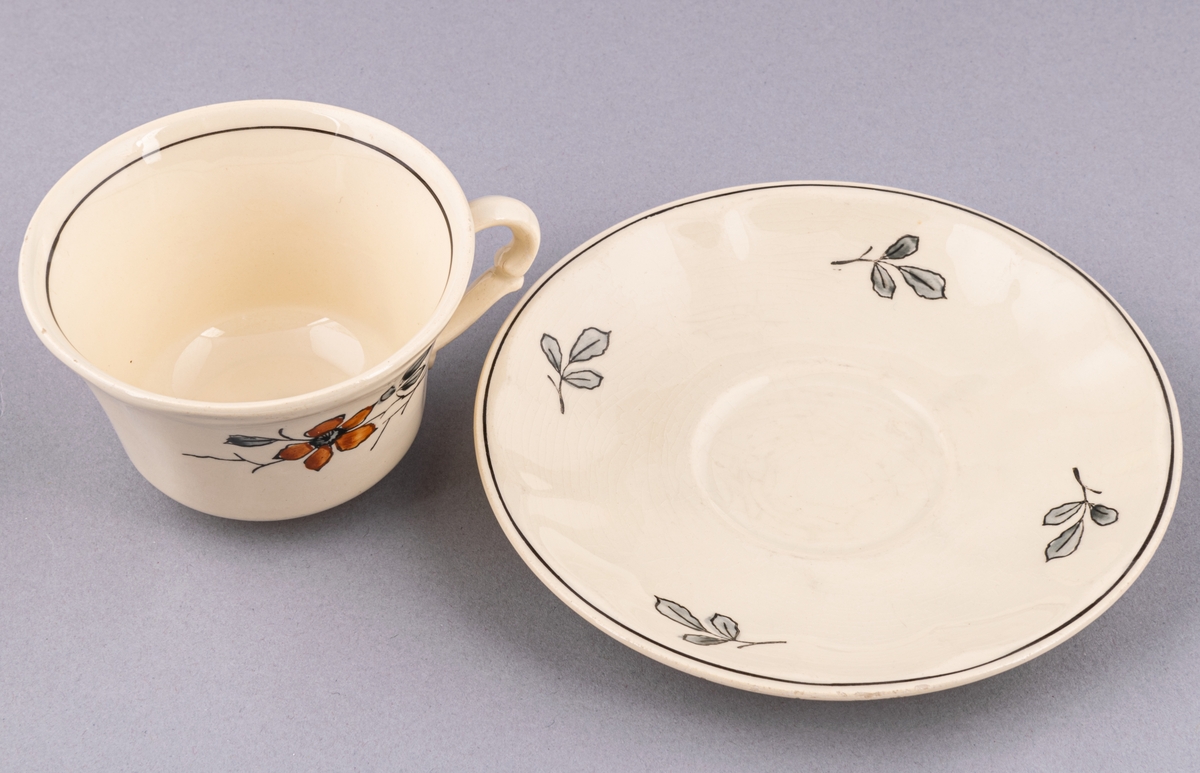 Kaffekopp med fat, i flintgods. Modell AK, dekor Bibo. Vit glasyr med flerfärgat blommönster. Skapad av Eugen Trost för Gefle Porslinsfabrik 1936.