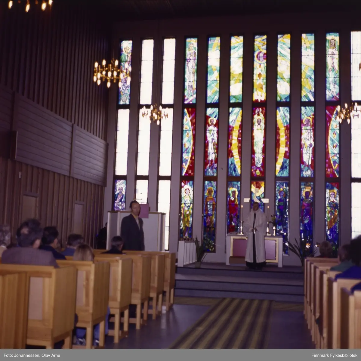 Båtsfjord kirke i ca. 1978-1982. Ved alteret står daværende sogneprest Anders Kvalevåg som var prest i Båtsfjord i nevnte periode. Båtsfjord kirke innviet i 1971.