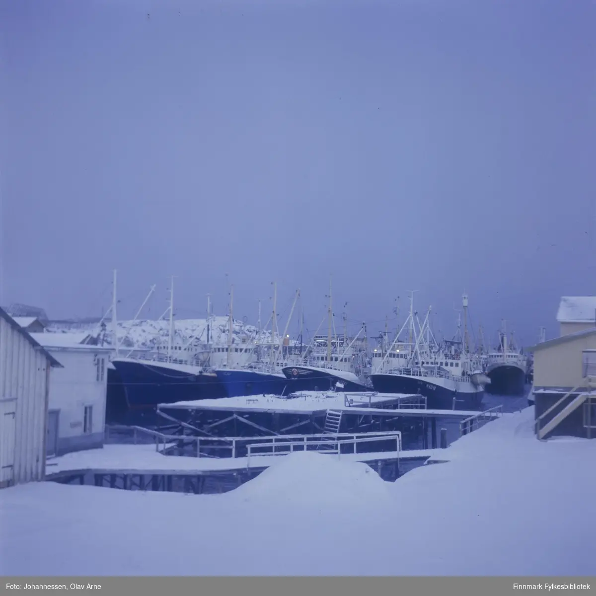 Foto av Båtsfjord havn 

Inforamnt: I midten kan man se en branntomt etter et hus som brant, trolig sent på 1960-tallet

Husene i forgrunen tilhørte fiskebruket "Produksjonslageret" som ikke lenger eksisterer
