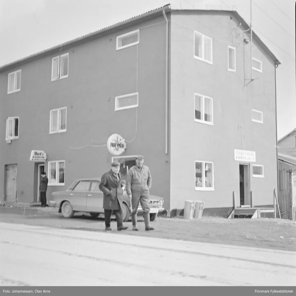 Ølbrakka (Øllager og Britt Eriksen Parfymeri) i Båtsfjord, Finnmark 

To menn går på gaten,  Kristian Sabbasen til venstre. 

Foto trolig tatt på tidlig 1970-tallet