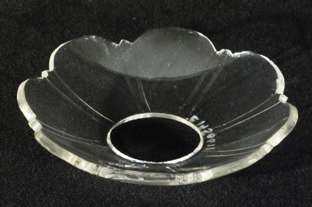 En av ett par ljusmanschetter av glas, manschetterna är något kupade och har omväxlande uddig och spetsig kant, ristade linjer från spetsarna till mitten av manschetter, några små nagg vid kanten, se inventnr c14302.
nyreg Data 010807 ks