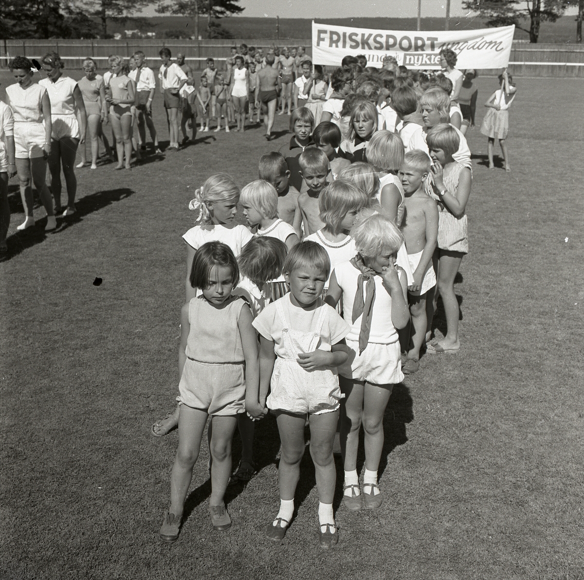 Grupper med barn och ungdomar under Svenska Frisksportförbundets banderoll på Långnäs den 12-19 juni 1959.