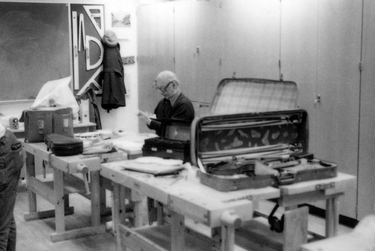 Fiolbyggarkurs i Fyllingeskolans slöjdsal, Halmstad under ledning av Thorsten Sandberg.
Motivtext foto 1: F d tryckeriägaren Sture Rydberg putsar på halsen.
Motivtext foto 2: Sture Rydberg t v och på fiol Anders Jägsell.
Motivtext foto 3: Thorsten Sandberg t h visar Kjell Pihl som gör en ny greppbräda till en trasig fiol.
Motivtext foto 4-5: Anders Bäckman skär det sista av spåret som ådern ska ligga i.
Motivtext foto 6: Anders Jägsell har limmat ihop botten och sarg och halsen.
Motivtext foto 7-9: Ove Lindahl och hans "arbetsplats". Han filar kanterna på locket. Botten och sarg ligger färdiga.
Motivext foto 10: Kjell Pihl arbetar med greppbräda av ebenholz.
Motitext foto 11: Thorsten Sandberg håller på att göra i ordning åskådningsmaterial till museets vandringsutställning.
Motivtext foto 12-14: Sture Rydberg slipar halsen. På hyvelbänken ligger lock, botten och mall och många redskap.
Motivtext foto 15-16: se neg nr 9-11. Foto 7-9.
Motivtext foto 17: Sture Rydberg.
Motivtext foto 18-19: Ove Lindahl.
Motivtext foto 20: Thorsten Sandberg.
Motivtext foto 21-22: Thorsten Sandberg hjälper Sture Rydberg. Halsens anslutning till fiolen riktas med en bräda.
Motivtext foto 23-29: Justering av basbjälken, som sitter limmad på insidan av locket. Thorsten Sandberg skär bort en del, knackar i träet och hör på ljudet.