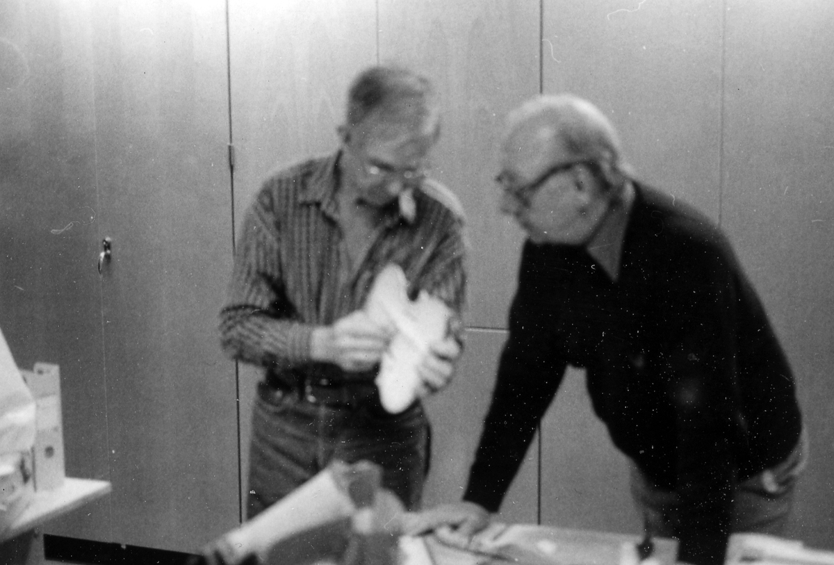 Fiolbyggarkurs i Fyllingeskolans slöjdsal, Halmstad under ledning av Thorsten Sandberg.
Motivtext foto 1: F d tryckeriägaren Sture Rydberg putsar på halsen.
Motivtext foto 2: Sture Rydberg t v och på fiol Anders Jägsell.
Motivtext foto 3: Thorsten Sandberg t h visar Kjell Pihl som gör en ny greppbräda till en trasig fiol.
Motivtext foto 4-5: Anders Bäckman skär det sista av spåret som ådern ska ligga i.
Motivtext foto 6: Anders Jägsell har limmat ihop botten och sarg och halsen.
Motivtext foto 7-9: Ove Lindahl och hans "arbetsplats". Han filar kanterna på locket. Botten och sarg ligger färdiga.
Motivext foto 10: Kjell Pihl arbetar med greppbräda av ebenholz.
Motitext foto 11: Thorsten Sandberg håller på att göra i ordning åskådningsmaterial till museets vandringsutställning.
Motivtext foto 12-14: Sture Rydberg slipar halsen. På hyvelbänken ligger lock, botten och mall och många redskap.
Motivtext foto 15-16: se neg nr 9-11. Foto 7-9.
Motivtext foto 17: Sture Rydberg.
Motivtext foto 18-19: Ove Lindahl.
Motivtext foto 20: Thorsten Sandberg.
Motivtext foto 21-22: Thorsten Sandberg hjälper Sture Rydberg. Halsens anslutning till fiolen riktas med en bräda.
Motivtext foto 23-29: Justering av basbjälken, som sitter limmad på insidan av locket. Thorsten Sandberg skär bort en del, knackar i träet och hör på ljudet.