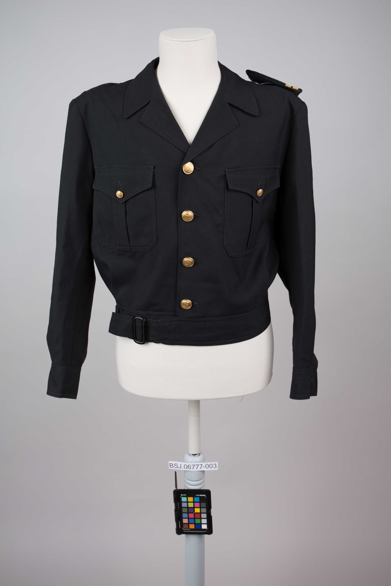 Battleuniformjakke  for elektriker. Kort jakke med belte i linning. Med til sammen 4 gullknapper i front. To mindre gullknapper over brystlommer.Mangler en skulderklaff.