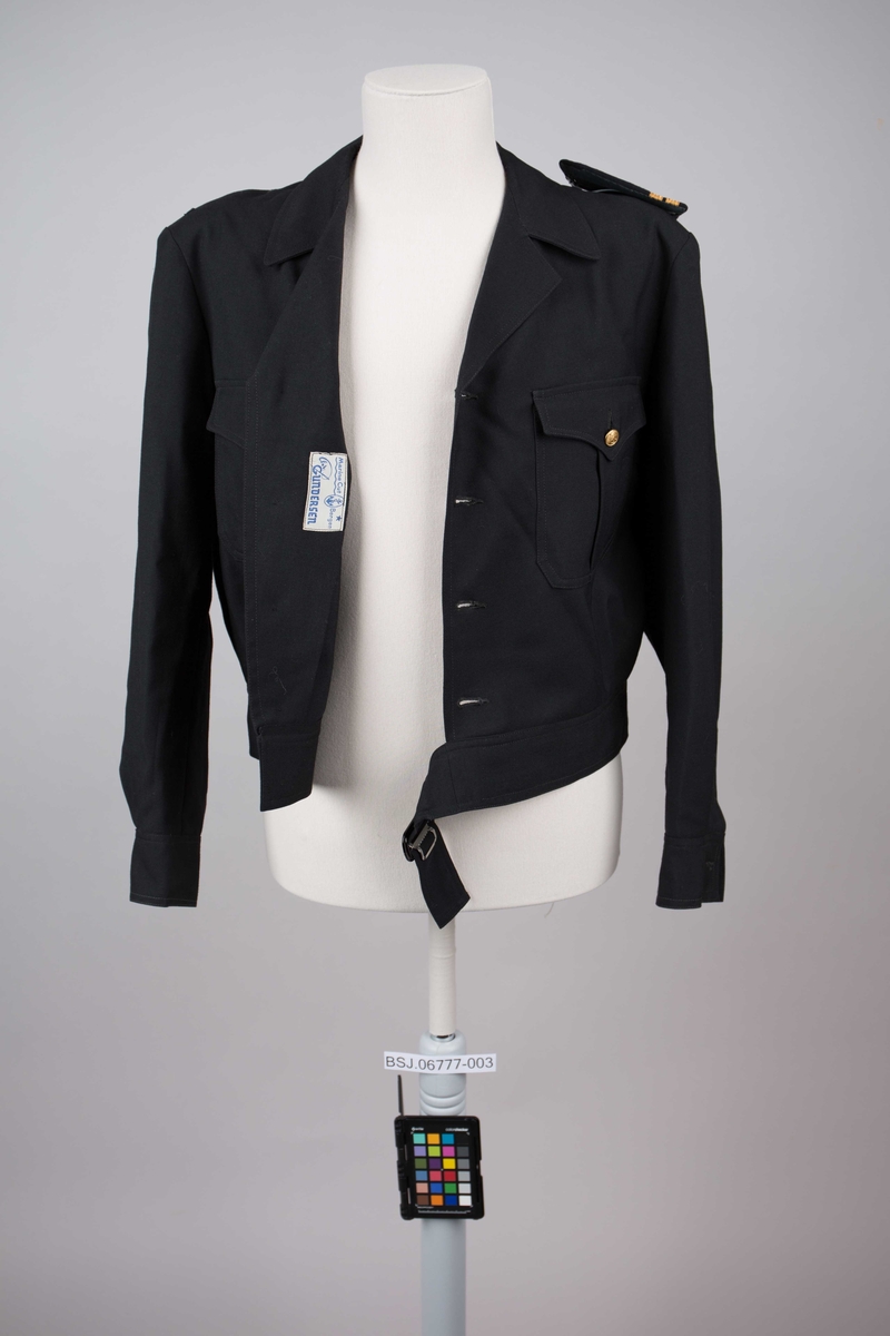Battleuniformjakke  for elektriker. Kort jakke med belte i linning. Med til sammen 4 gullknapper i front. To mindre gullknapper over brystlommer.Mangler en skulderklaff.