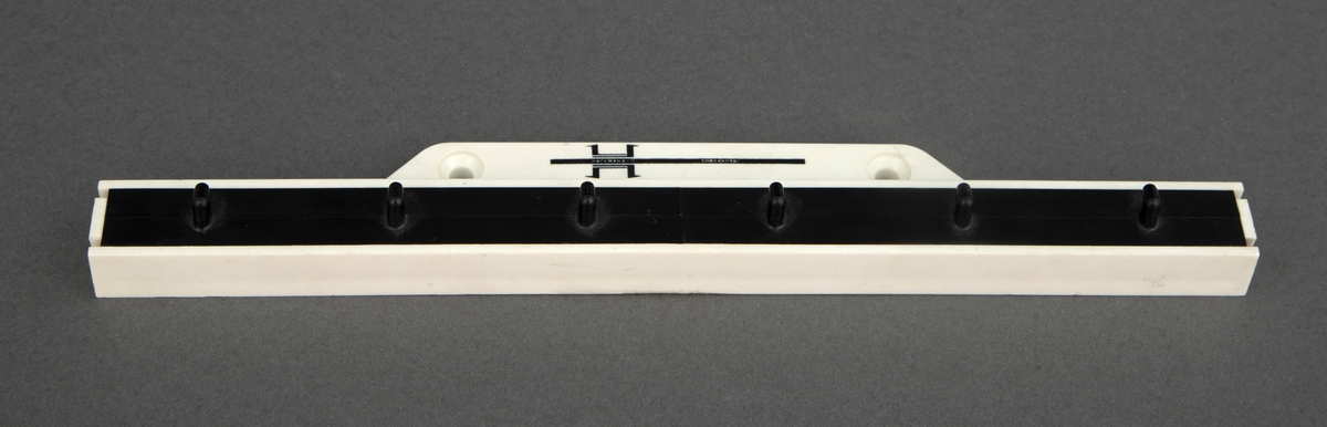 Knaggrekke av hvit plast med plass til seks kniver.