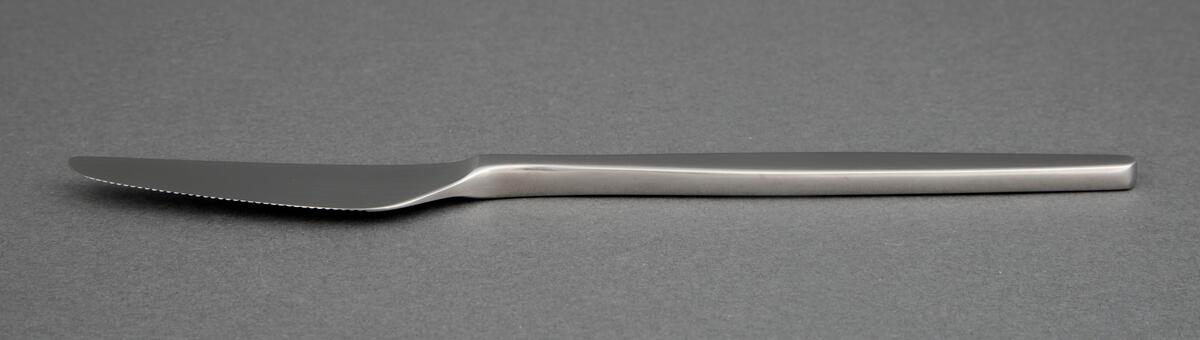 Bordkniv i presset rustfritt stål med knivblad i avrundet trekantform og små tagger. Tilnærmet rett linje fra bladrygg til skaft. Skaftet er smalt ved skaftroten og tiltar i bredde mot midten, for så å minske igjen mot enden som har rett avslutning.
