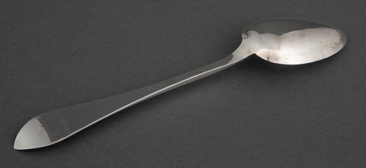 Spiseskje i sølv. Spisst, eggformet skjeblad og skaft som tiltar i bredde mot skaftenden som har spiss og lett oppbøyd avslutning. Dekor med to fabeldyr og bladranker.