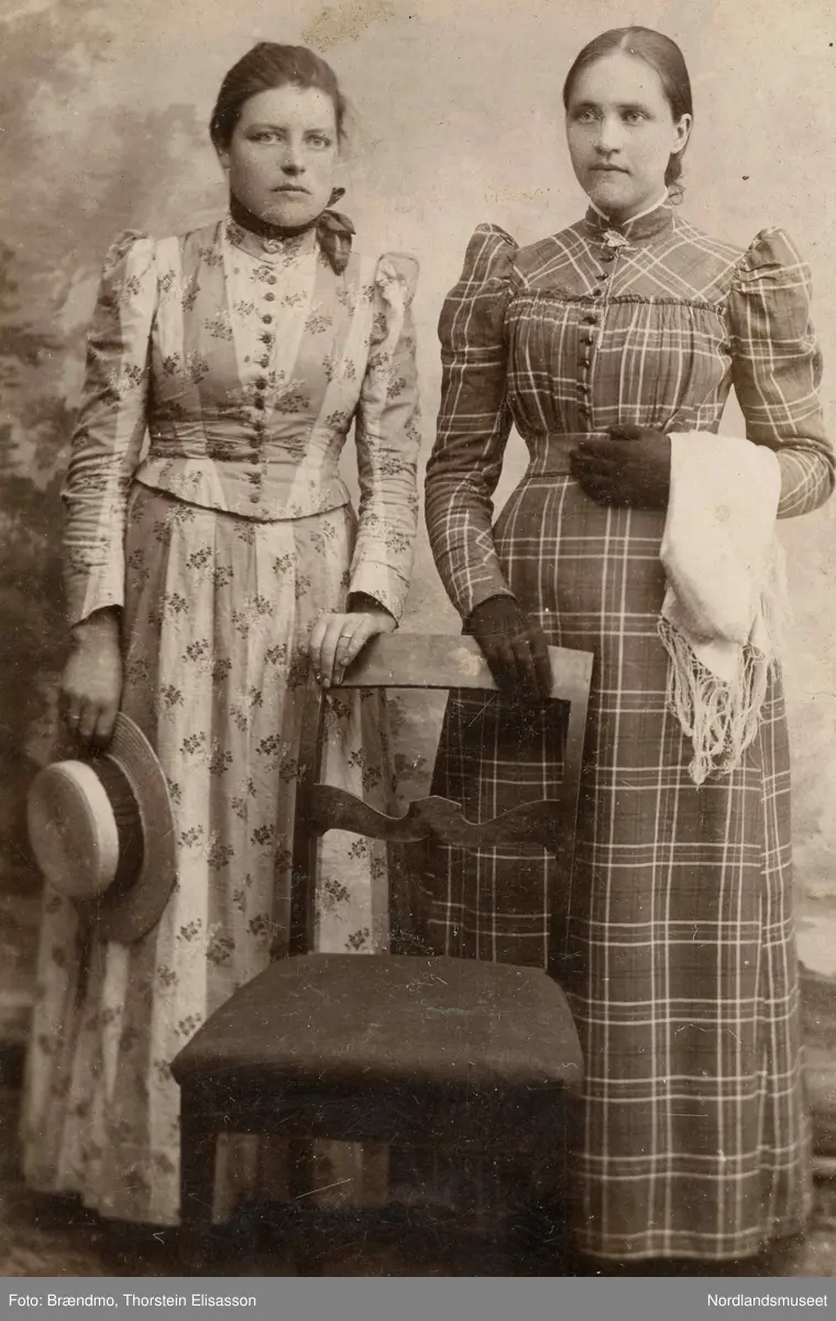 Portrett av to kvinner. Til venstre står Olea Elisabet Olsdtr. Danielsen (f. 1870), fra Røssøya på Engeløya.