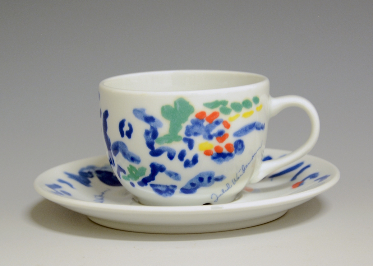 Kopp av porselen med hvit glasur. Derkorert med nonfigurativt motiv i blått, gult, grønt og rødt.
Modell: Roma av Grete Rønning
Dekor etter motiv av Jakob Weidemann