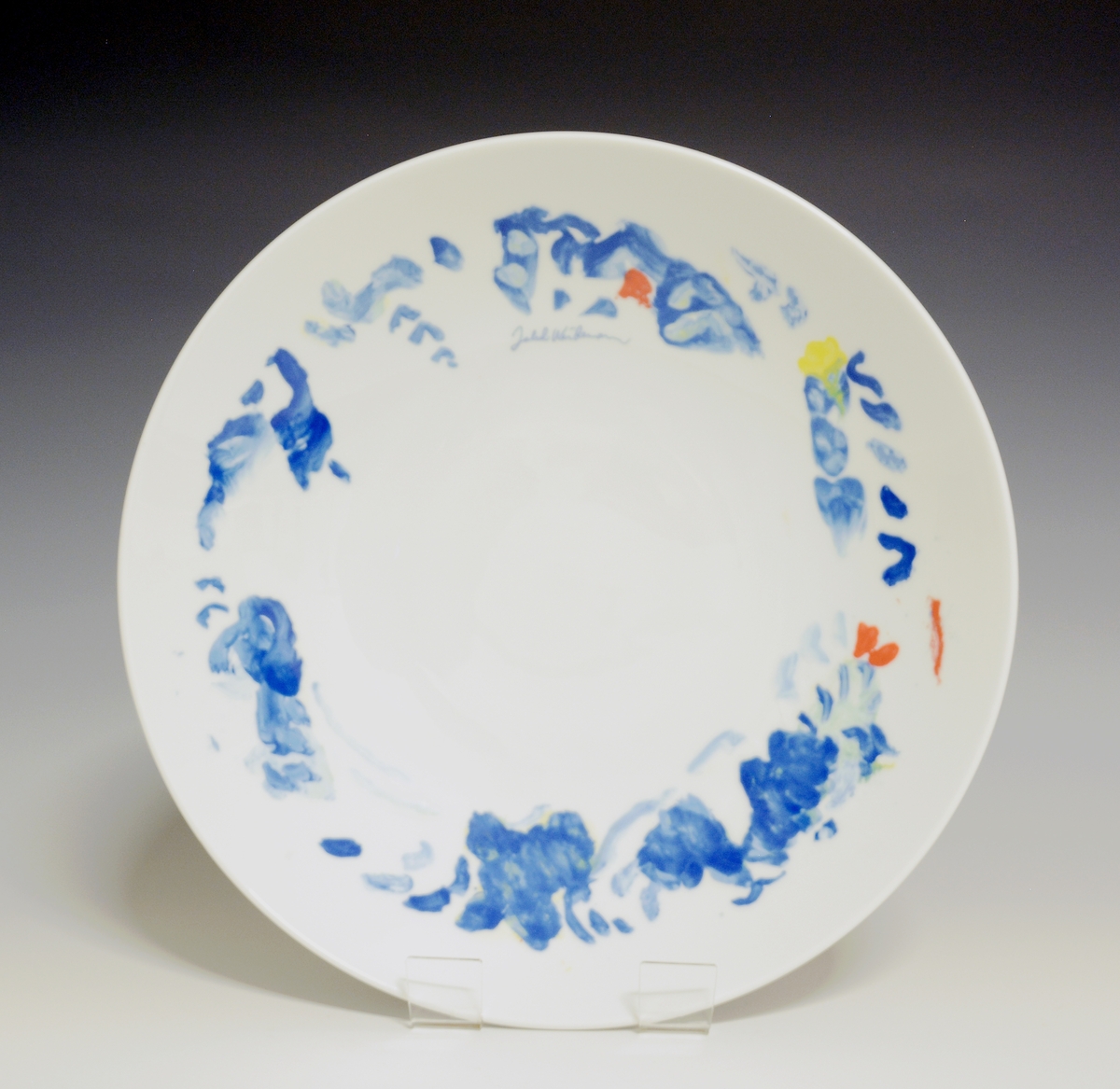 Fat av porselen med hvit glasur. Dekorert med nonfigurativt motiv i blått, gult, grønt og rødt. Jakob Weidemanns signatur på fanen.
Modell: 2591.4
Dekor etter motiv av Jakob Weidemann
Prøve