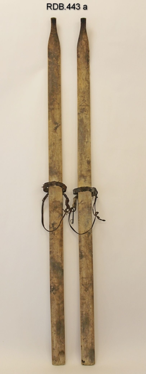 Et par jevnbrede helved treski med lang, spiss skitupp. Lav skibrett. Tre innrissede dekorstriper langs kanten og innrisset geometrisk figur foran og bak på skiet. Hull gjennom skiet som bindingene er  tredd gjennom. Tåbinding av lær forsterket med blikkplate og hælbinding (snor) av lær. 1 styrerand ("eggel") under. Slitte fotsteg.

Treskiene bærer preg av samisk skikultur.