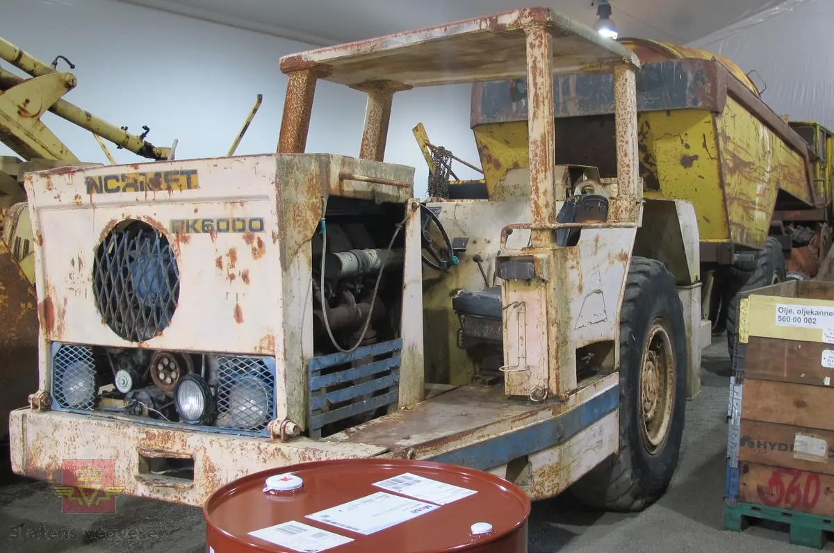 Normet PK 6000 D. 24 tonns gul dumper med 4 hjul, 2 akslinger. 6-sylindret luftavkjølt 9,6 liters Deutz dieselmotor med betegnelsen F6L 413 FW som yter 139 hk. Motoren har motornummer 6581711. Rammestyrt med 3 gir fremover, og revers. Dumperens toppfart er på 25 km/t. Har dumperkasse på 7 m3.