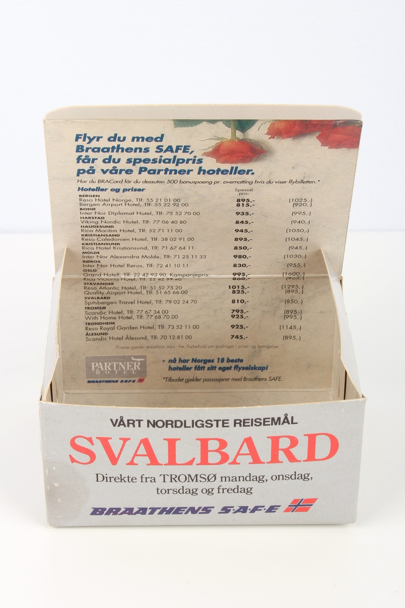 Eske fra servering om bord flyvning. Esken inneholder en våtserviett, en liten sjokoladebit og sjokoladepapir.
Med trykt annonse for en hotellkjede inni esken.