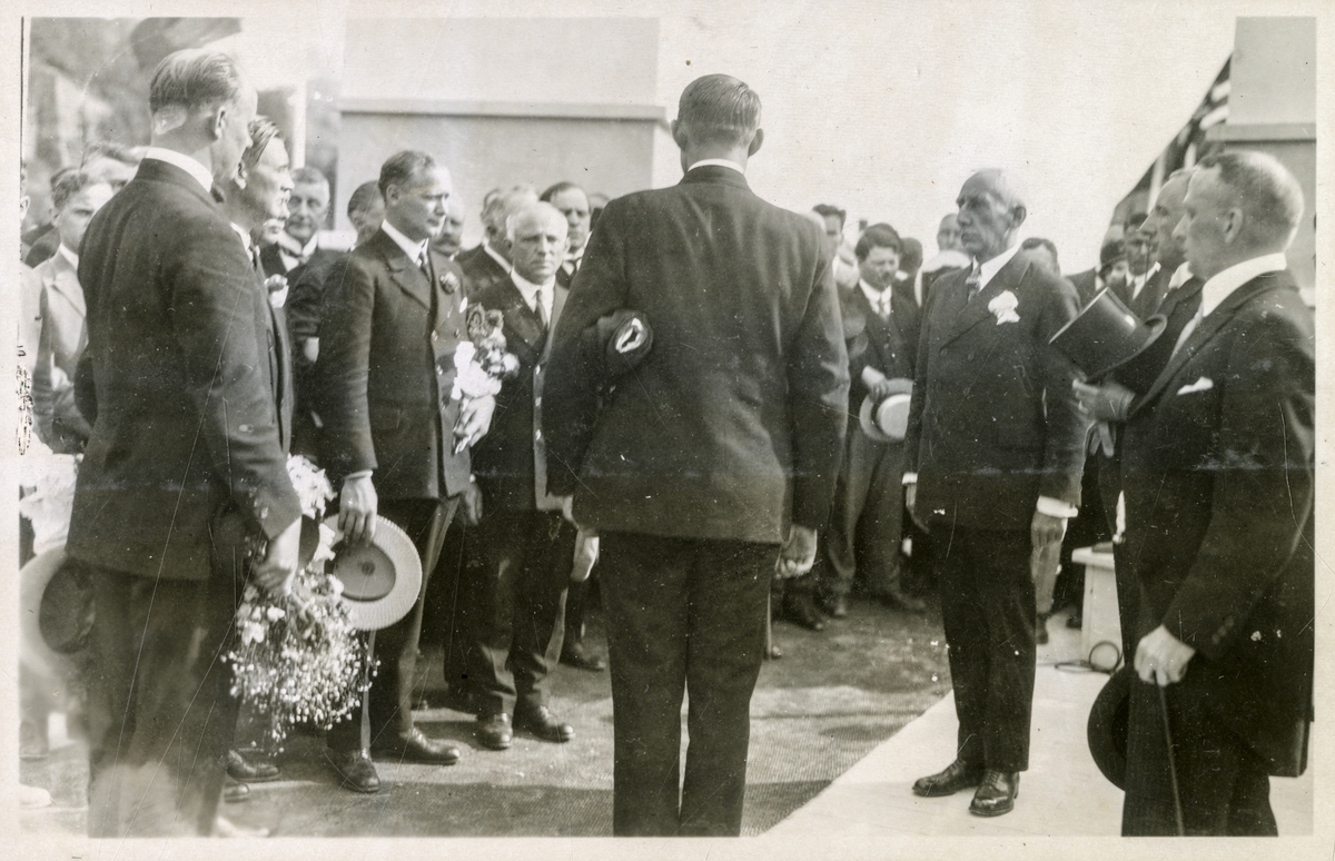 Roald Amundsen og ekspedisjonsdeltagerne på Honnørbrygga etter å ha mottatt blomster, trolig under avspilling av nasjonalsangen (Bilde 2) - Roald Amundsens ankomst til Oslo med S/S "Bergensfjord" efter "Norge"s færden over Polen - 16. juli 1926.