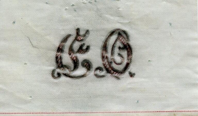 Broderimönster, ljusblått/grått papper, förvaras i ett ljusgrått kuvert. Okänd ålder. Kuvertet märkt med blyerts; "Monogram E.O". Motiv: olika monogram i rött och svart; "EO", "EM" samt "GERD". Papperna är något nötta. Del av en samling textilmönster från samma donation, förvaras i en mapp (C25324_1).