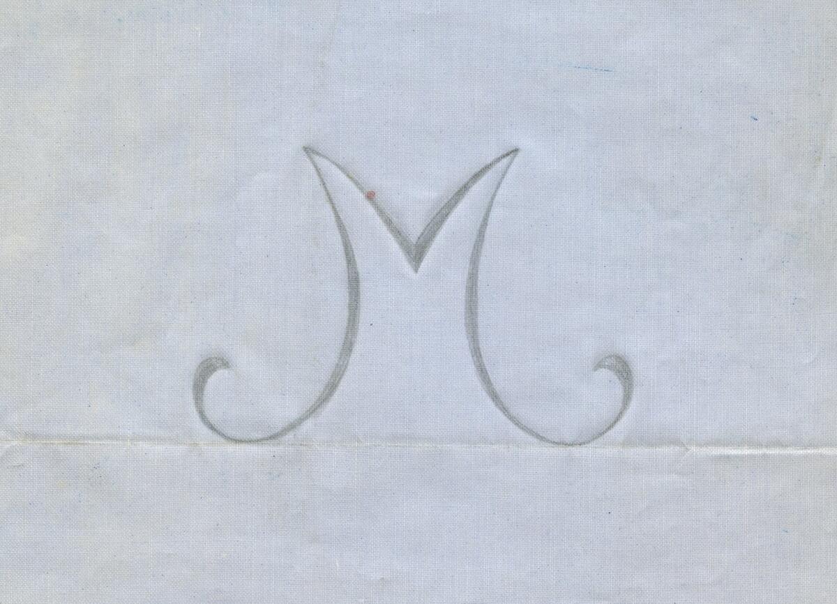 Broderimönster, ljusblått/grått papper, 11 st. i olika storlekar. Okänd ålder. Motiv: olika monogram; "M" och "MG" i olika varianter och konstellationer. Papperna något nötta, en del med permanenta veck efter att ha legat vikta under lång tid. Del av en samling textilmönster från samma donation, förvaras i en mapp (C25324_1).