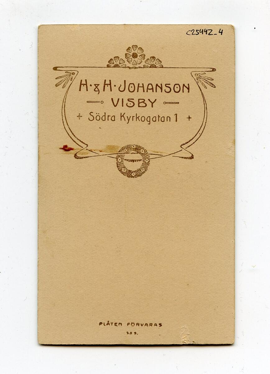 Porträttfotografi i visitkortsformat, tidigt 1900-tal. Bilden föreställer en oidentifierad ung man med ljust hår. Han är klädd i militäruniform med mörk krage. Fotograf: H&H Johanson i Visby. Del av en samling porträttfotografier från okänd givare.