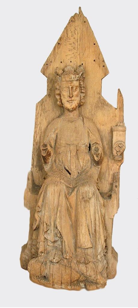 Skulptur av trä föreställande tronande manligt helgon med dorsale, troligen S:t Olof.

Helgonet bär en veckrik dräkt med skärp ovanför magen. Håret och skägget är halvlångt och lockigt. Han bär krona som till viss del är skadad (enligt originalkatalogen finns tre blad kvar). Båda underarmarna saknas. Helgonet trampar med skobeklädda fötter på en liggande figur - vilken är mycket skadad. Tronen med åsformat bakstycke är skadad och skulpturens baksida är urtagen.

Enligt Johnny Roosval i "Medeltida konst i Gotlands Fornsal" är skulpturen gjord av Dionysiusmästaren och dateras till höggotik (cirka 1295-1330). Roosval menar att figuren under helgonets fötter är trollet Skalle.