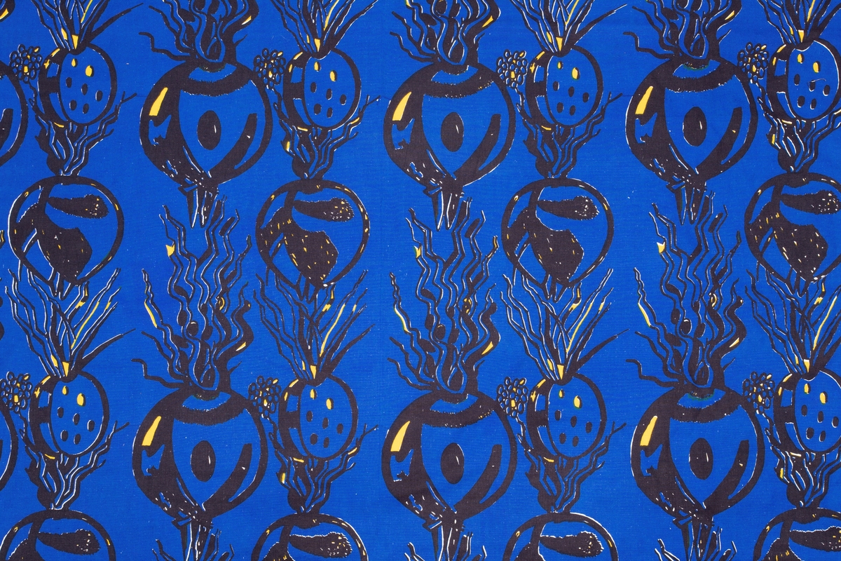 Håndtrykket mønstermotiv på vevd bomull. Stofftrykket er bortimot heldekkende mot det hvite bunnstoffet, med et motiv av røtter og spirer i sort og gult med blå bakgrunn.