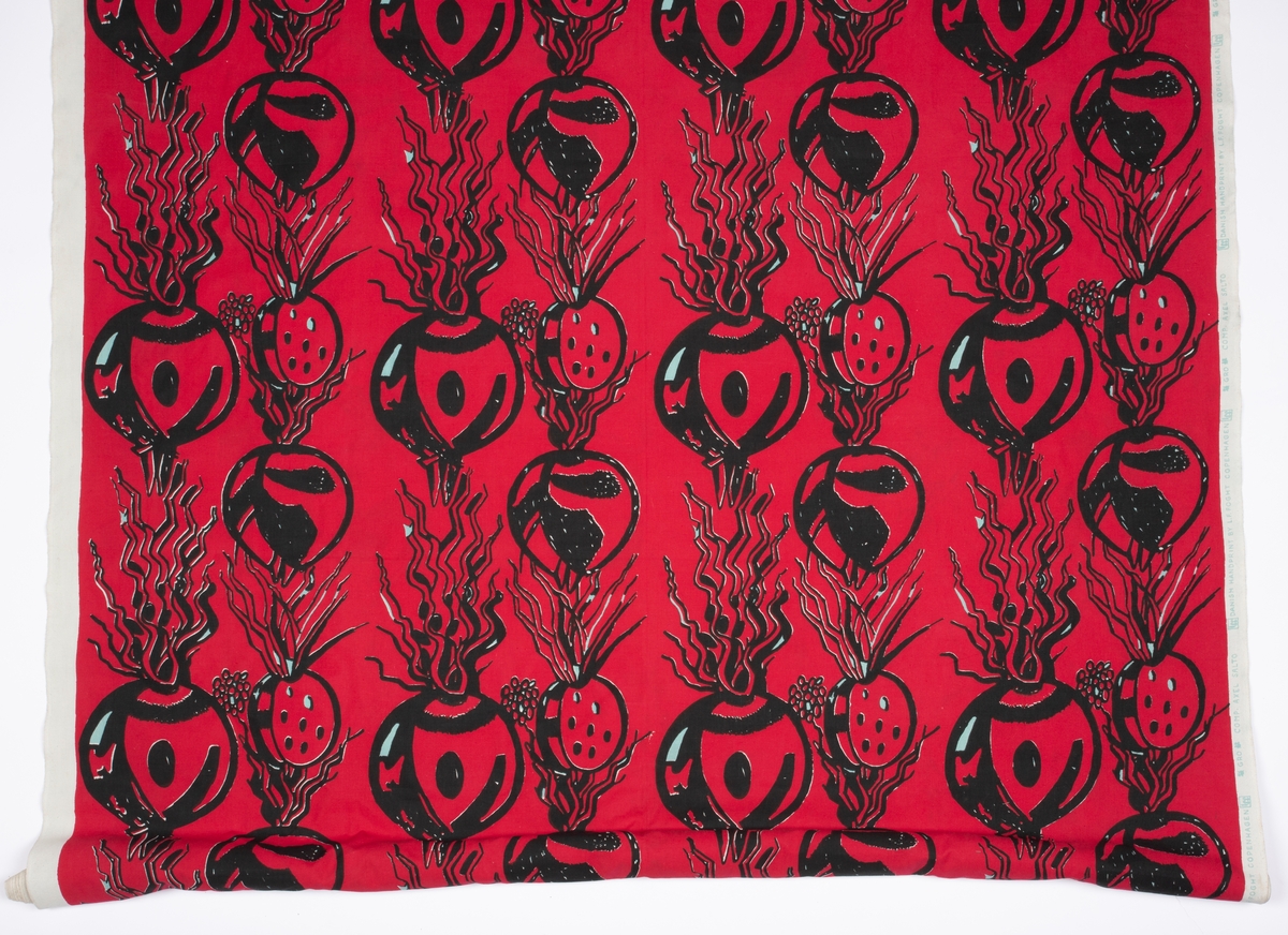 Håndtrykket mønstermotiv på vevd bomull. Stofftrykket er bortimot heldekkende mot det hvite bunnstoffet, med et motiv av røtter og spirer i sort med rød bakgrunn.
