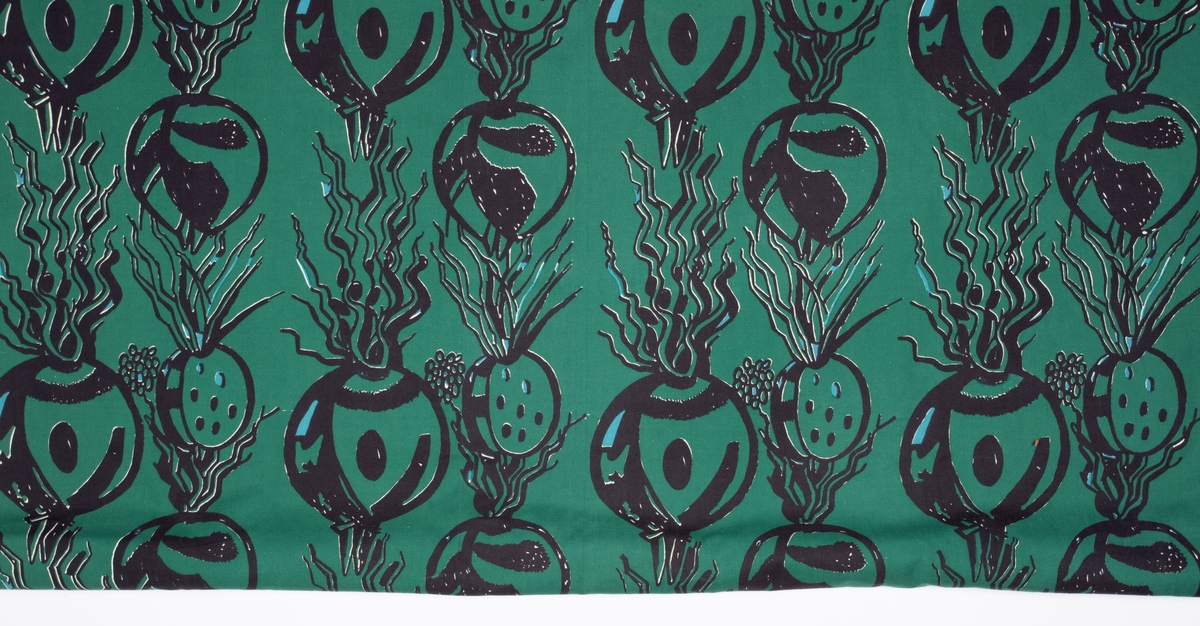 Håndtrykket mønstermotiv på vevd bomull. Stofftrykket er bortimot heldekkende mot det hvite bunnstoffet, med et motiv av røtter og spirer i sort og lyseblått med grønn bakgrunn.