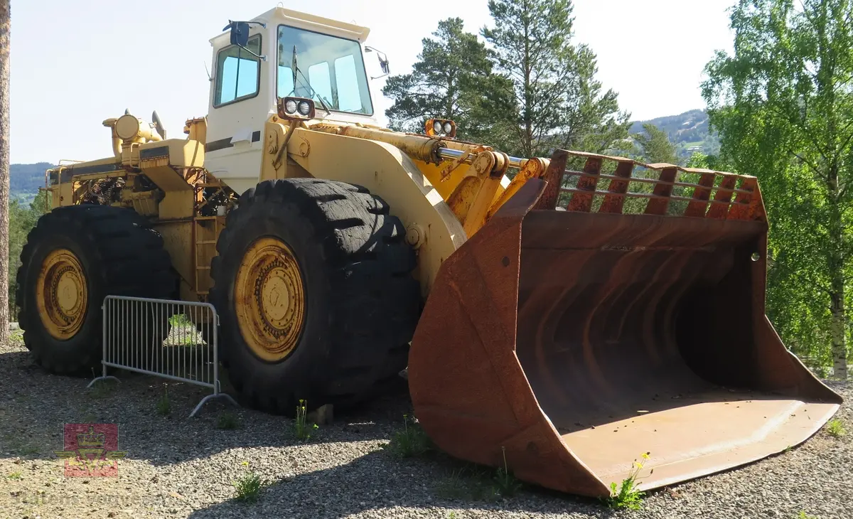 International H-400C Payloader. Hjullaster på 4 hjul, antatt 4-hjuls drift. Gul og svart. Motoren er en turboladet V12 Cummins type VT1710C-635. Dette er en 4-takts diesel med et cylindervolum på 1710 cu. in. (28 liter), Effekt 473.5 kw (635 hp). Skuffa rommer ni kubikkmeter.
Girkasse fra International Harvester, modellbetegnelse P-600S (to-trinns). Merking fra produsent og første bruker.