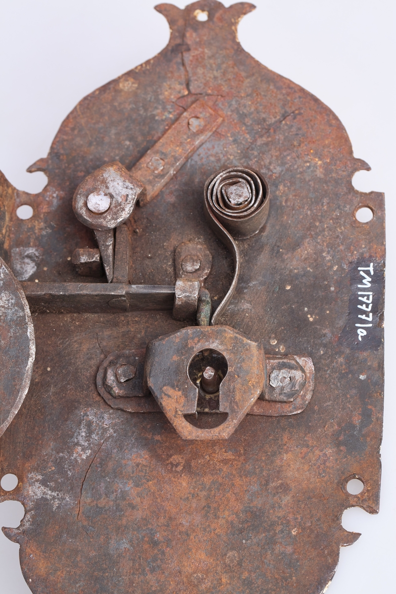 To deler av en lås a har mekanismen og b er et beslag tilå ha på andre siden av døren.