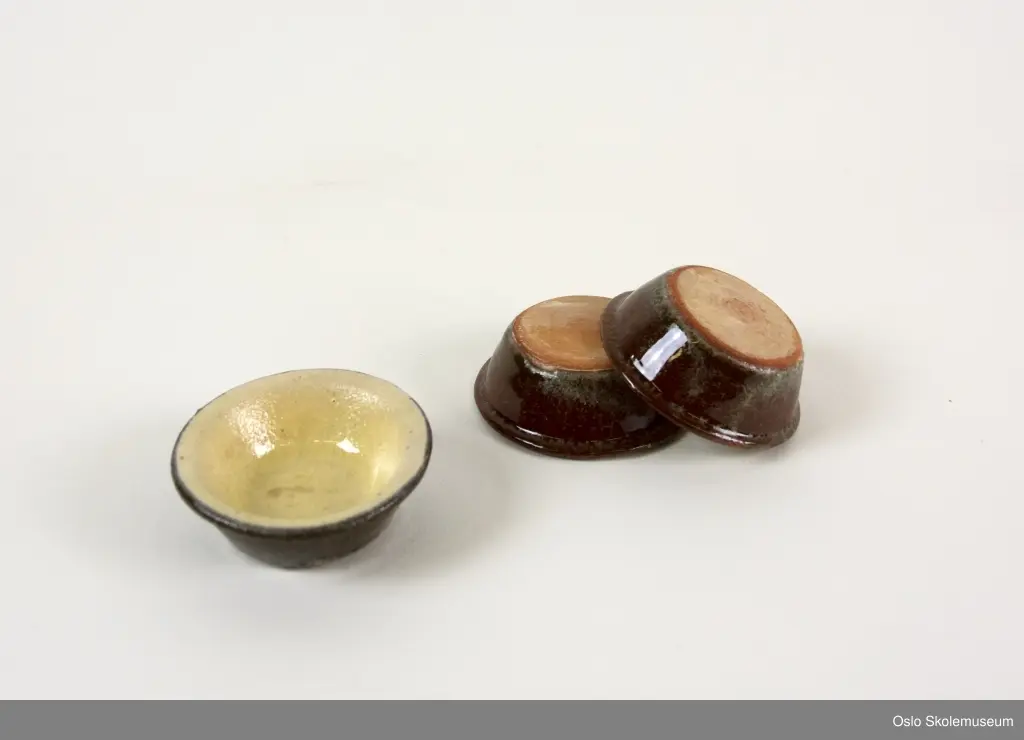 Tre boller i miniformat. Bollene har gul glassering på innsiden og brun glassering på utsiden.