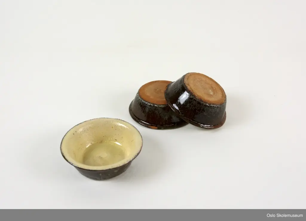 Tre boller i miniformat. Bollene har gul glassering på innsiden og brun glassering på utsiden.