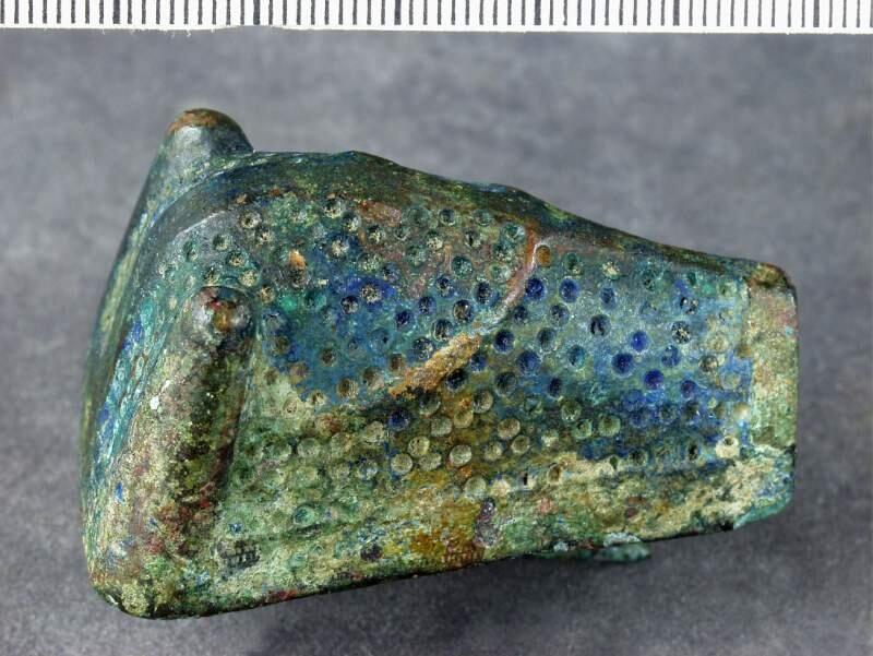 AV BRONS, DJURHUVUDFORMAT, LÄNGD 51, BR. 33, H. 25 MM. LIKNANDE "SV, FORNS". FIG. 535; BRED KANT NEDTILL, MITTLISTEN HAR EJ JÄMNLÖPANDE KANTER. FÖRUT MÄRKT 1153.