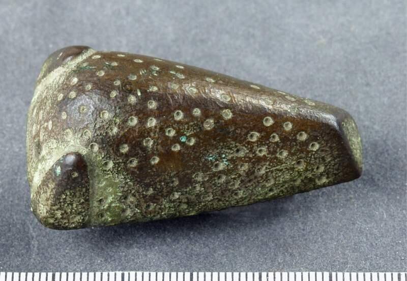 AV BRONS, DJURHUVUDFORMAT, LÄNGD 50, BR. 30, H. 18 MM. TYP LIK NR: 518. MEN HÅL BAKOM HÖGRA HÖRNSTOLPEN OCH NOSEN HAR 3 PUNKTER. (ENA SIDAN INBUKTAD, BOTTEN MED NÅL SAKNAS. FÖRUT MÄRKT 207.
