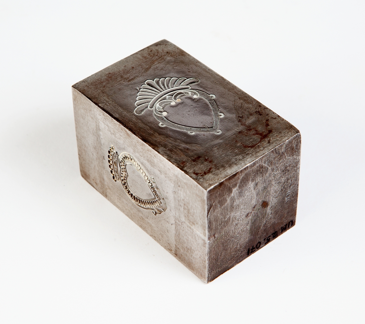 Rektangulär stans av järn till allmogebrosch. Har stansar på två sidor, till två olika broschmodeller.