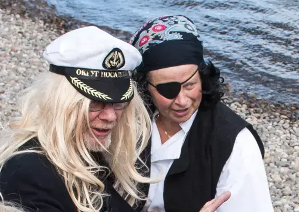 To utkledde "sjørøvere", en med kapteinslue og lang blond parykk, og en med svart øyelapp og hodetørkle. De ser lure og morsomme ut.