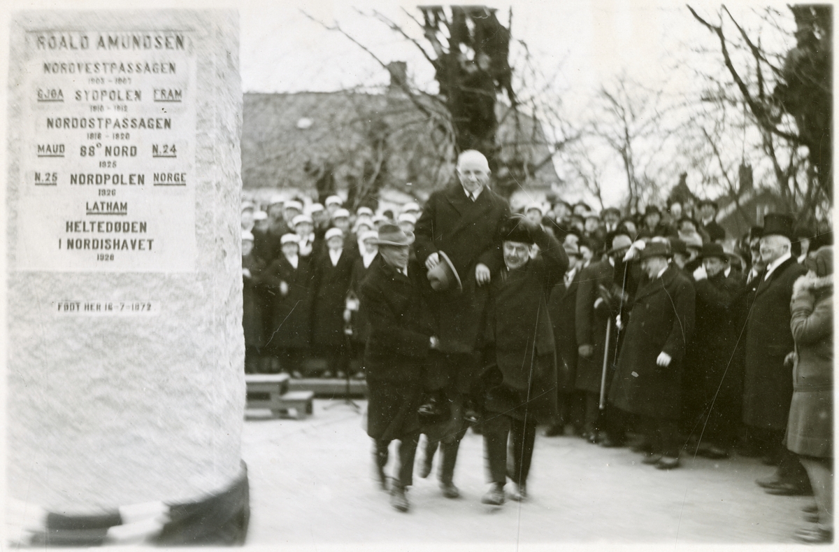Mann på "gullstol" og tilskuere etter avdukning av bautaen. Mannskor i bakgrunnen - Roald Amundsens bautasten avsløres ved Sarpsborg - 16. des. 1928.