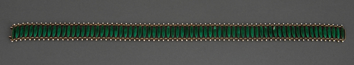 Halsband satt sammen av 72 tverrstaver dekket av grønn, halvtransparent emalje over guillochering. Leddenes form er spissoval med trepassformet utvidelse ved hver ende med huller for bøyler som holder leddene sammen og ytterst en "perle" i hvit emalje. Bakside og bøyler er av forgylt sølv. Hektelås til lukking av smykket.