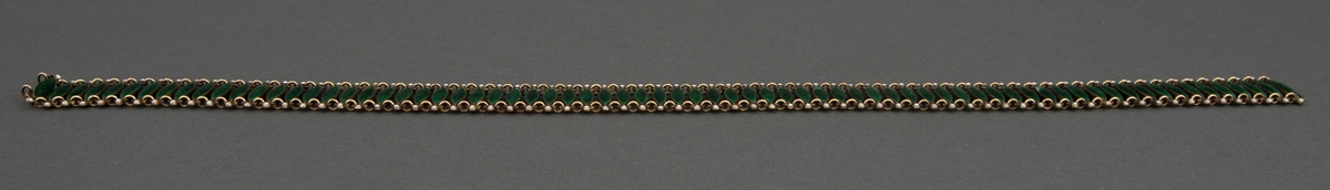 Halsband satt sammen av 72 tverrstaver dekket av grønn, halvtransparent emalje over guillochering. Leddenes form er spissoval med trepassformet utvidelse ved hver ende med huller for bøyler som holder leddene sammen og ytterst en "perle" i hvit emalje. Bakside og bøyler er av forgylt sølv. Hektelås til lukking av smykket.