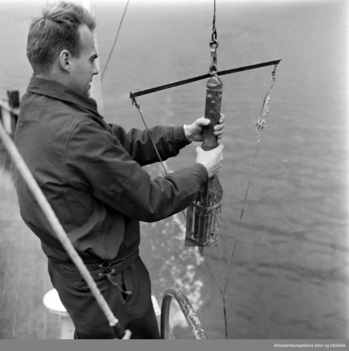 Lasse Berglind fra Vannforskningsinstituttet tar vannprøver i Indre Oslofjord. Bilde fra forskningskutteren "Gunnar Knudsen". Oktober 1960
