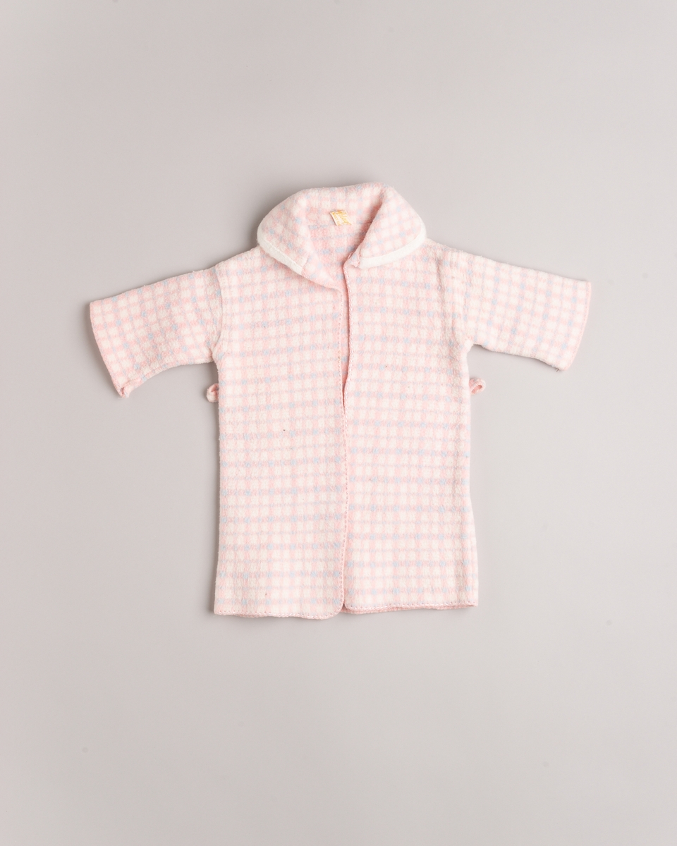 Babypose med kåpe. Posen lukkes med fire knapper. Kåpen har hatt belte.
Baby- og barnetøy som først var brukt av tre søstre i USA på 1930- og 40-tallet, før det ble sendt til Norge og brukt av tre søstre i Eidsberg på 1940- og 50-tallet - kusiner av de tre i USA.