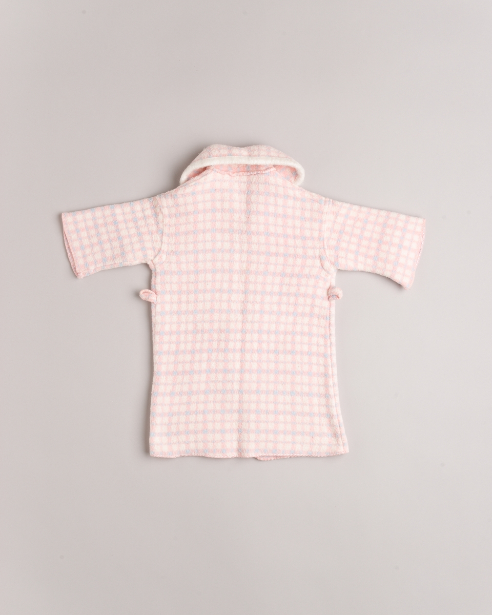 Babypose med kåpe. Posen lukkes med fire knapper. Kåpen har hatt belte.
Baby- og barnetøy som først var brukt av tre søstre i USA på 1930- og 40-tallet, før det ble sendt til Norge og brukt av tre søstre i Eidsberg på 1940- og 50-tallet - kusiner av de tre i USA.
